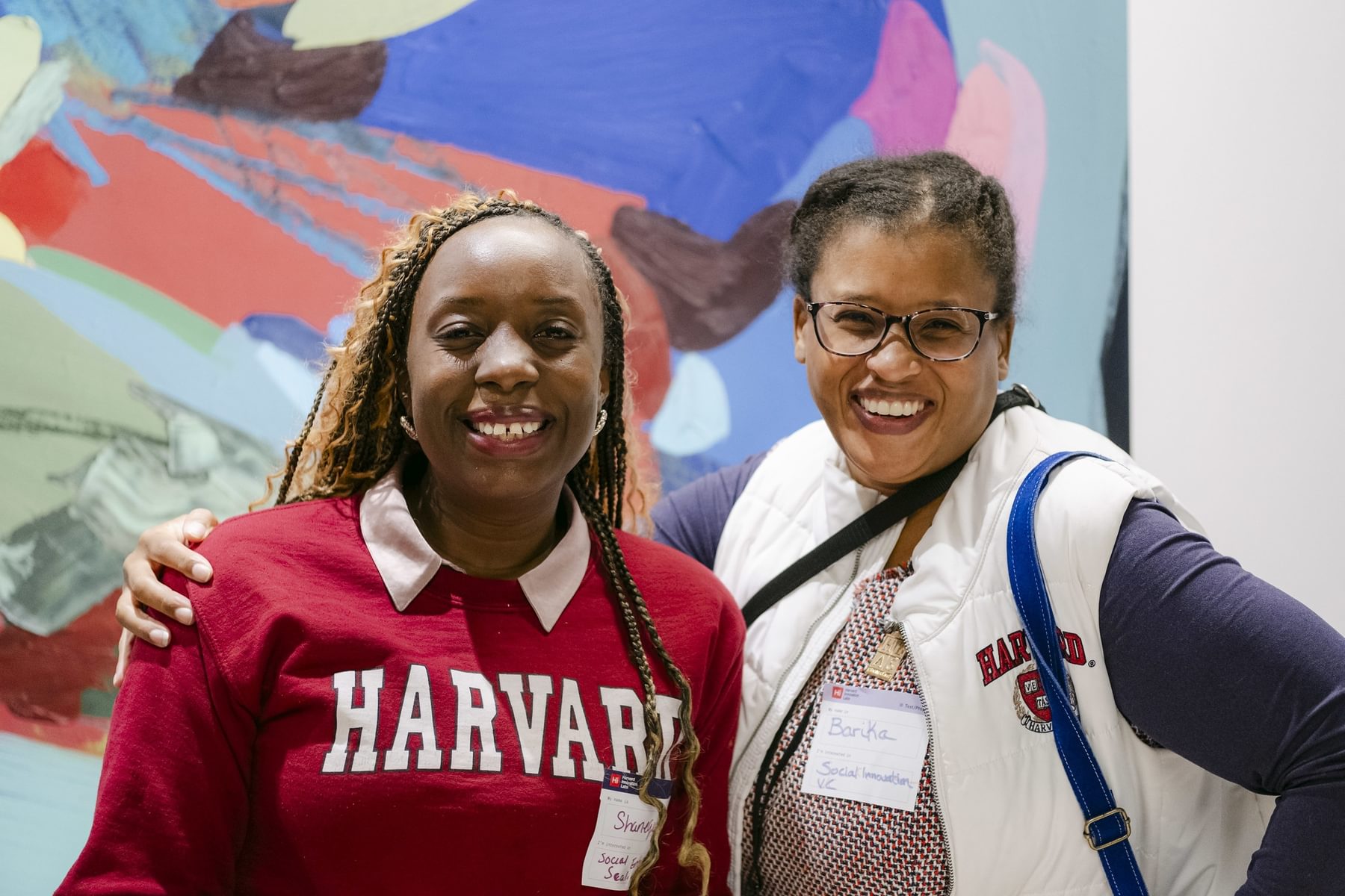 two women wearing Harvard sweatshirts smiling