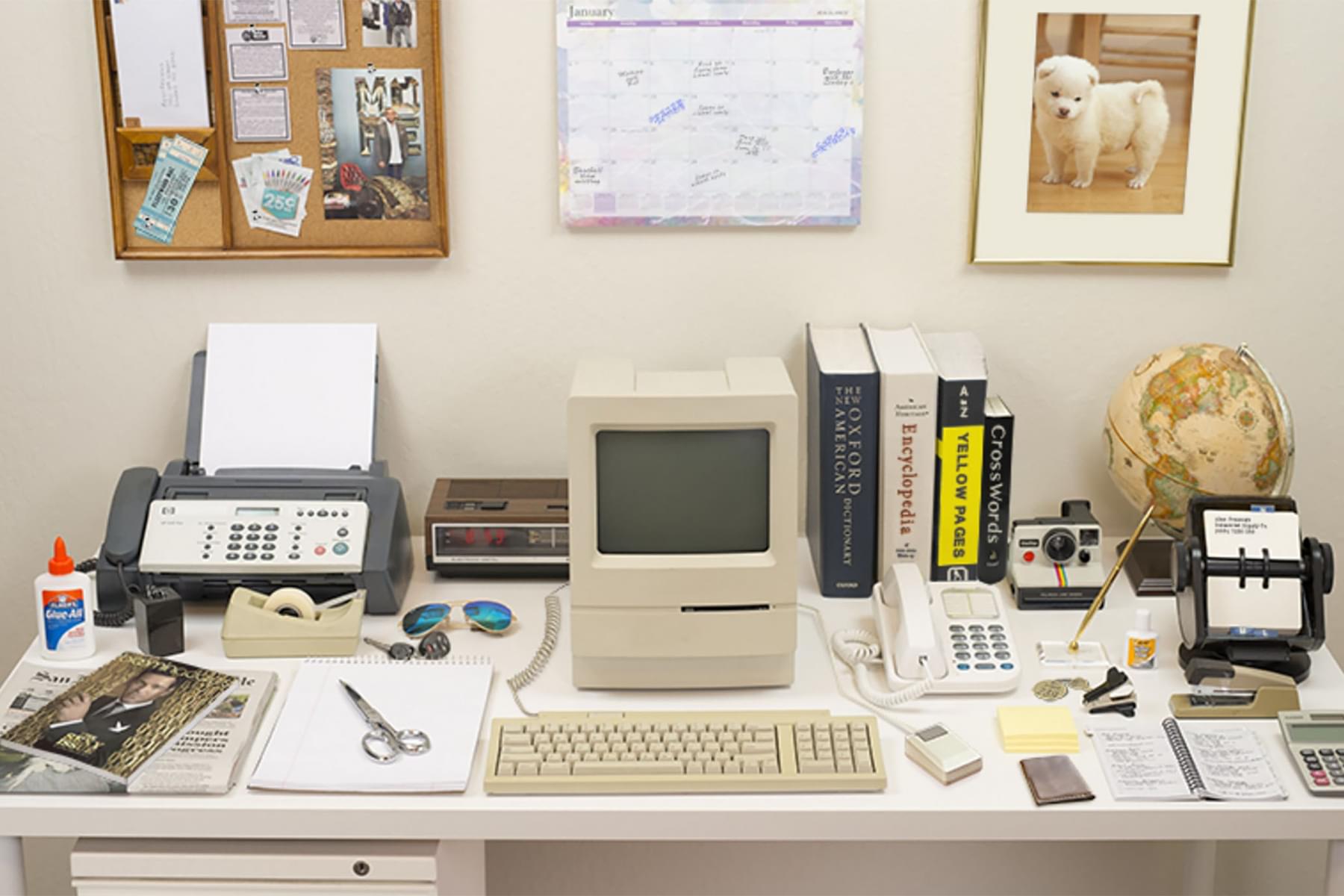Picture of a desk with a computer, printer, and various office supplies